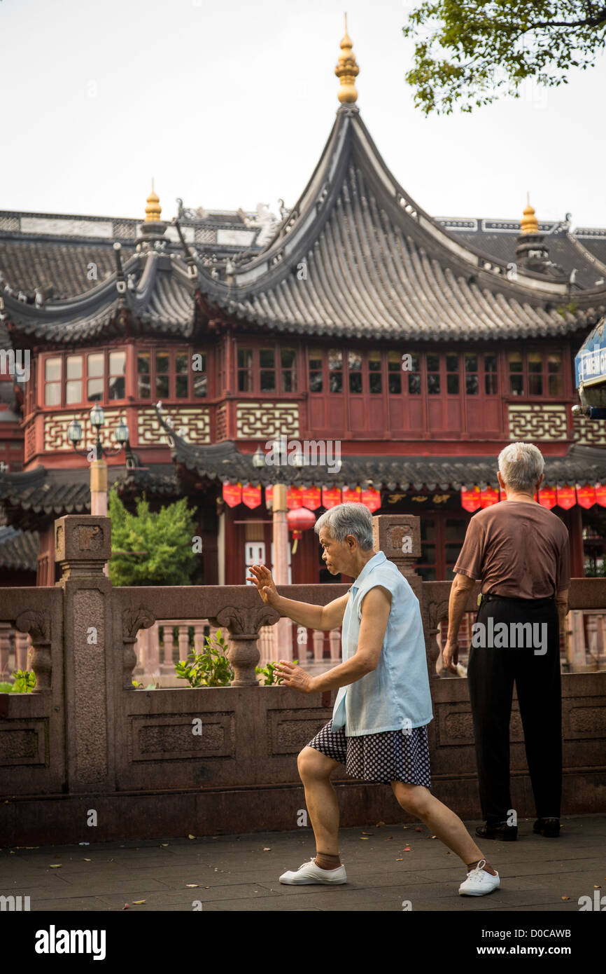 An elderly woman practices Tai Chi in front of the Huxinting Teahouse in Yu Yuan Gardens Shanghai, China Stock Photo