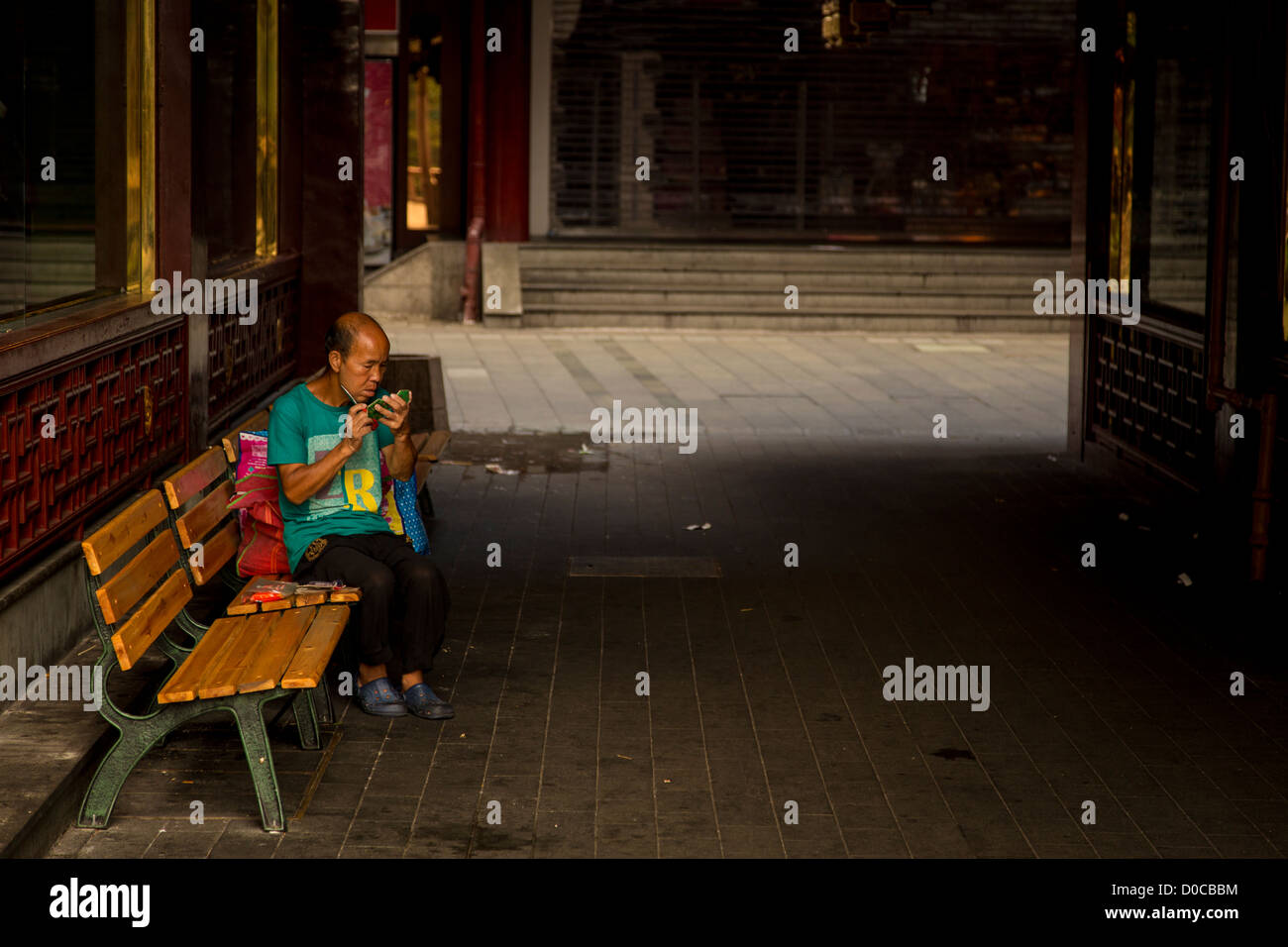 A homeless man shaves in the Yu Yuan bazaar in Shanghai, China Stock Photo