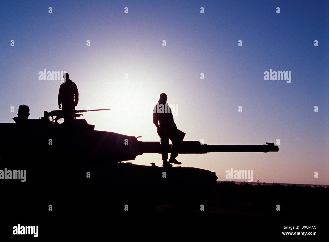 Silhouettes of US Marines on M1A1 Battle Tank at Sunrise Stock Photo