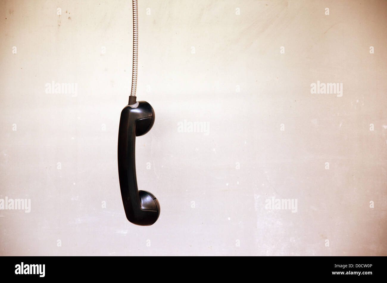 Hanging vintage phone receiver over a grunge background Stock Photo