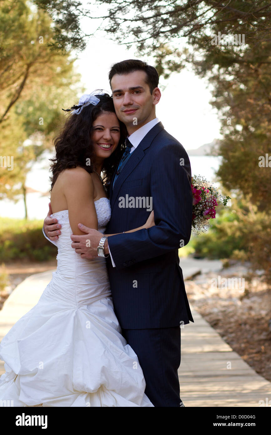 Happy newlyweds posing in the park after their wedding Stock Photo - Alamy