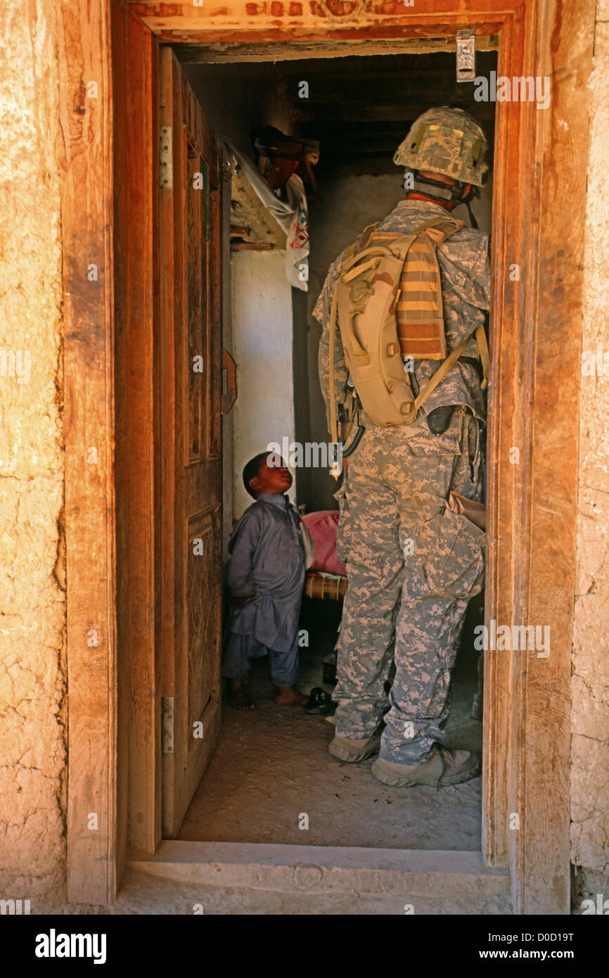 A Young Afghan Boy Looks at a US Army Soldier During a Raid on a Suspected Al Qaeda Training Camp Stock Photo