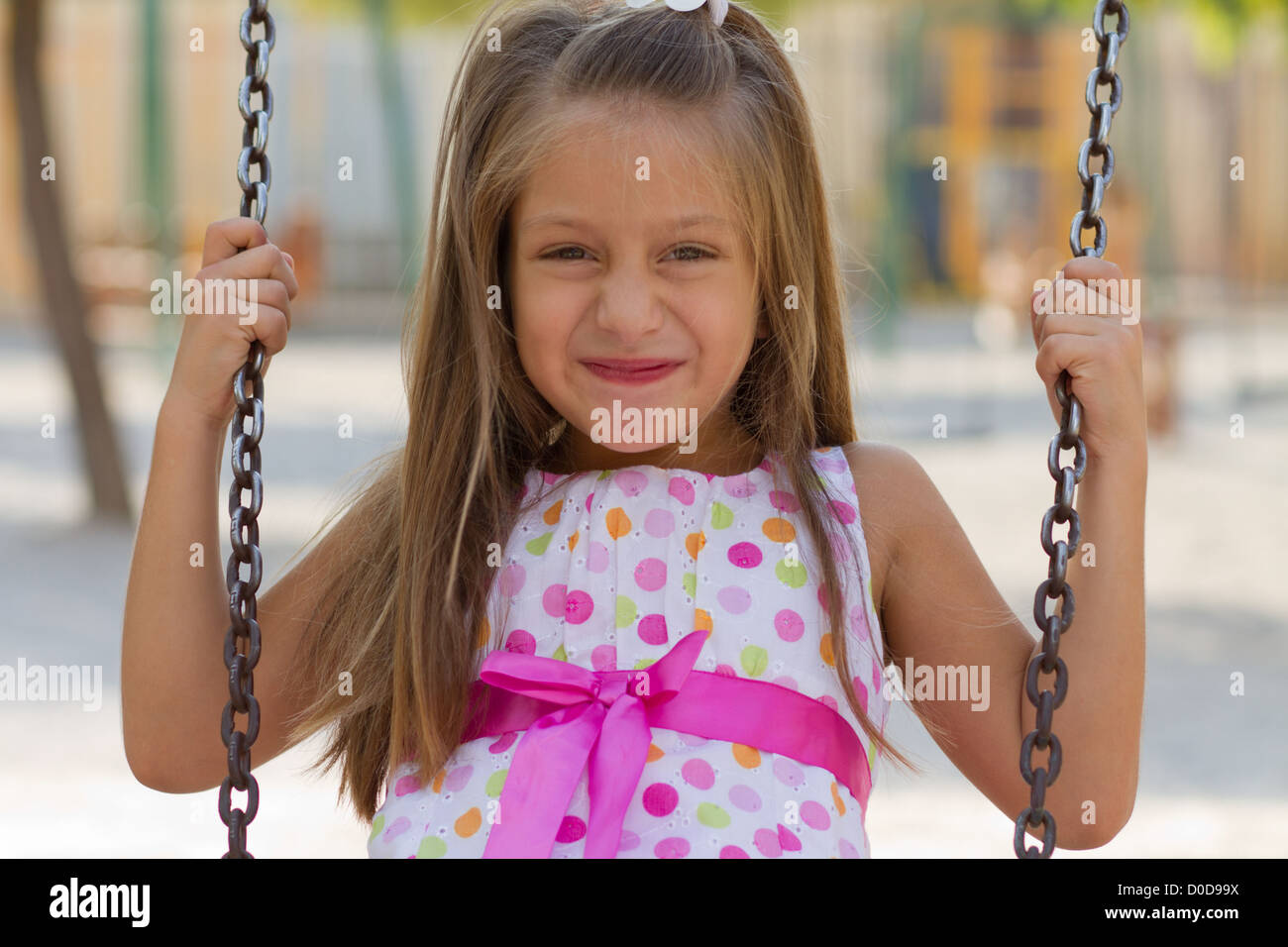 Cute little girl posing on the playgorund at bright summer day Stock ...