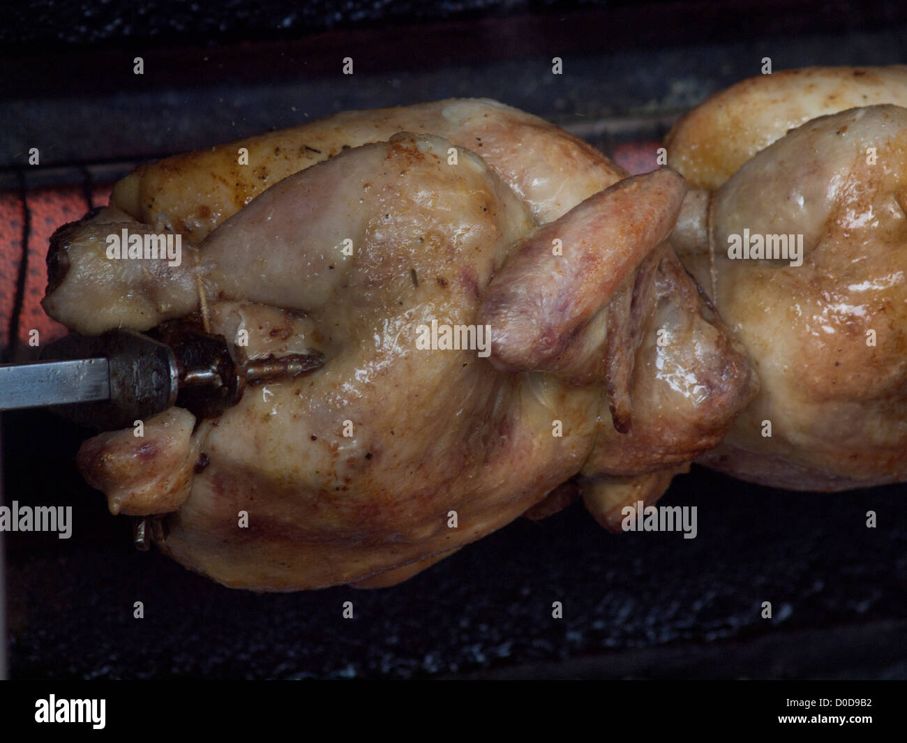Chickens roasting on a spit at a village market in Northern France. 
