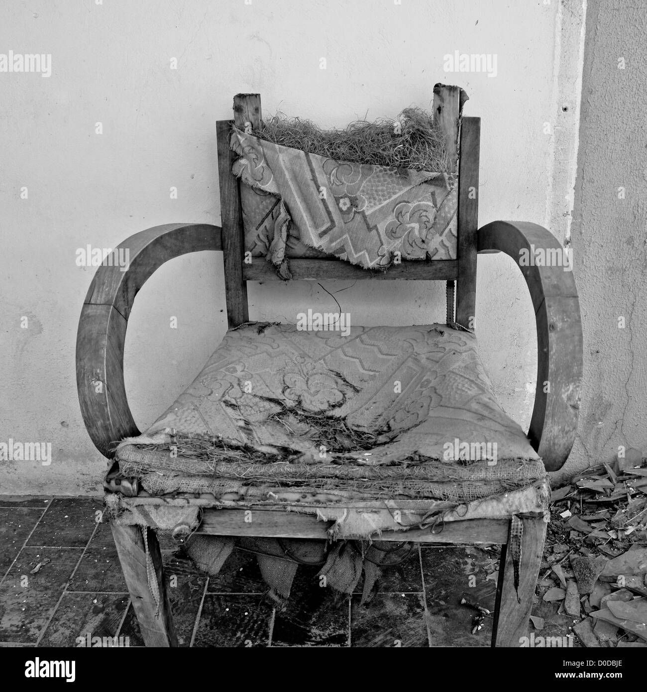 Torn armchair and pile of broken glass. Black and white. Stock Photo