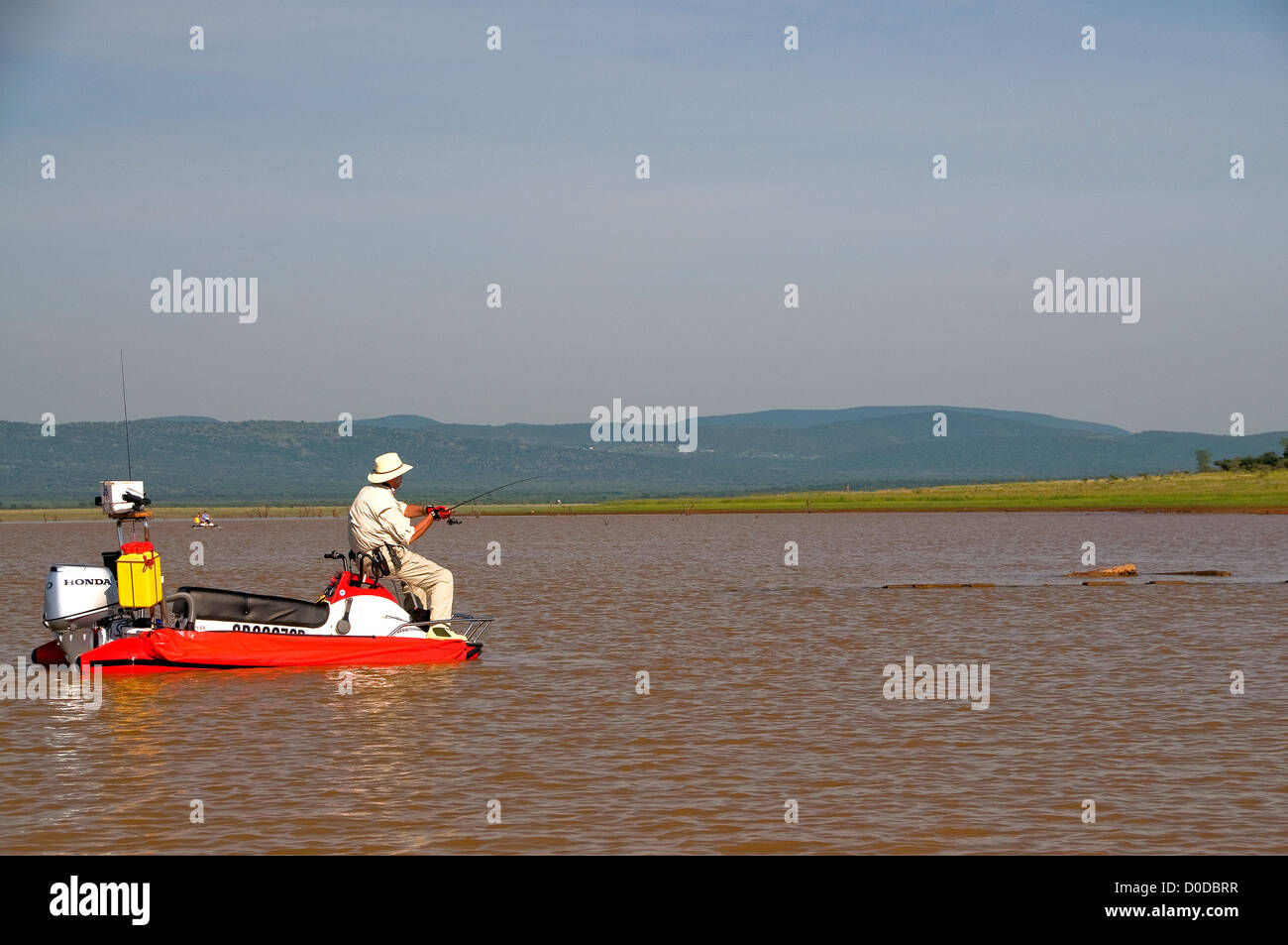 An angler on an AquaQuad boat casts for tiger fish in pretty Lake Jozini on Phongolo GR, KwaZulu Natal, South Africa. Stock Photo