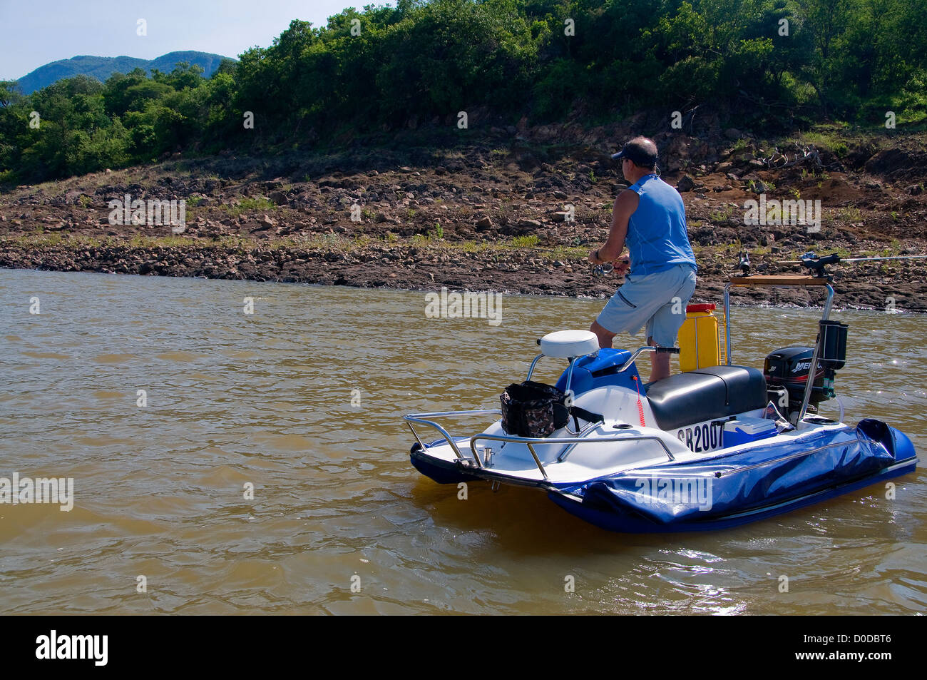 An angler on an AquaQuad boat casts for tiger fish in pretty Lake Jozini on Phongolo GR, KwaZulu Natal, South Africa. Stock Photo