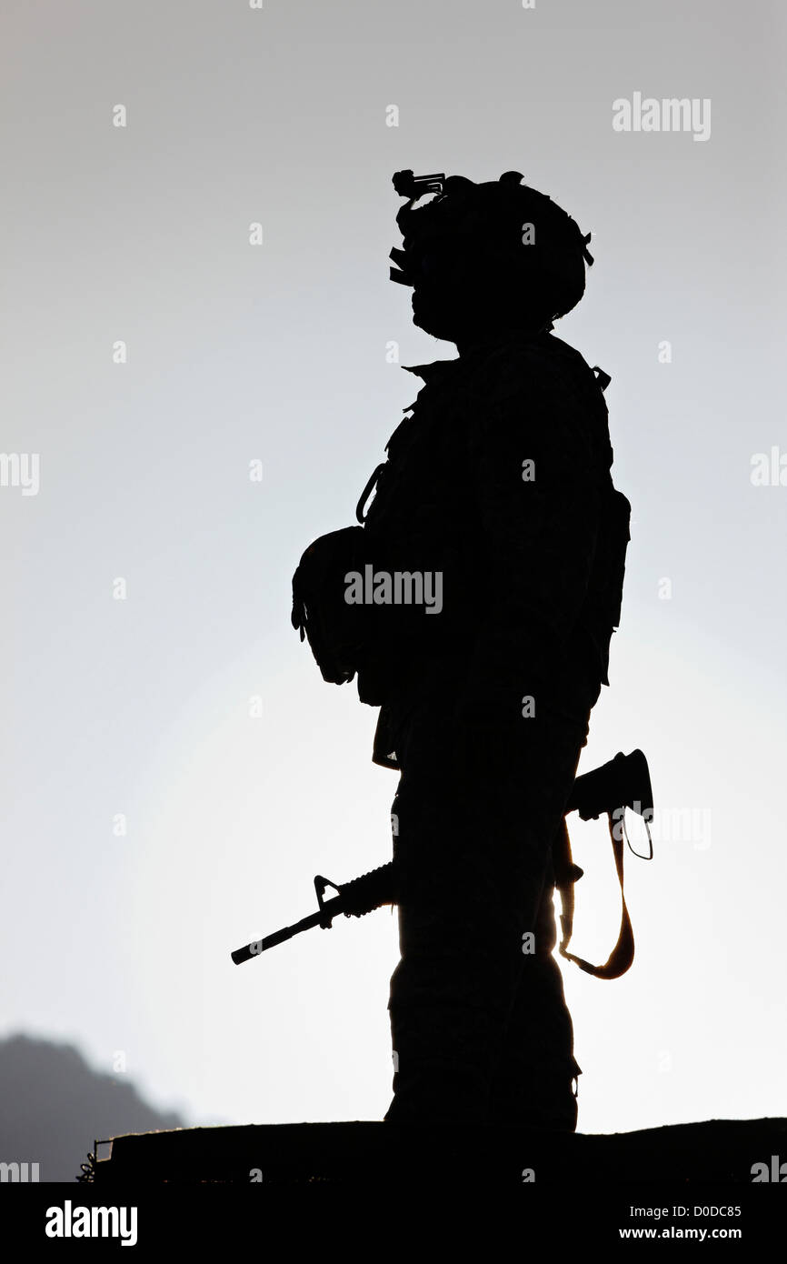 U.S. Army Soldier Holding His Weapon at Sunrise Stock Photo