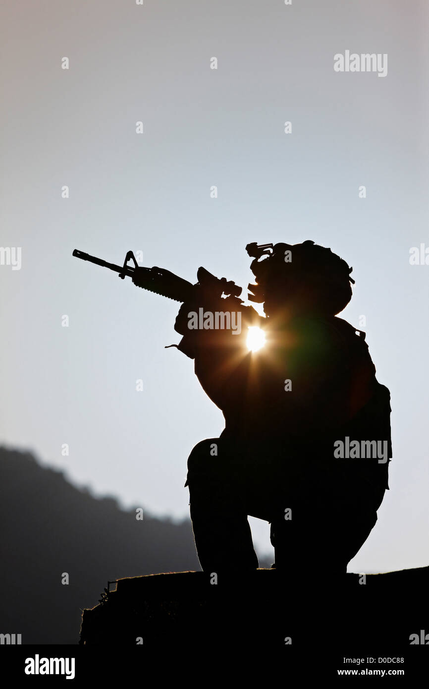 U.S. Army Soldier Holding His Weapon at Sunrise Stock Photo