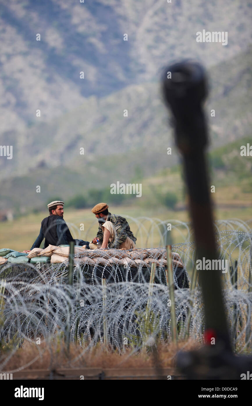 Two Afghan Men, Dressed in Traditional Pashtun Clothes Atop a Sandbagged Barrier Stock Photo