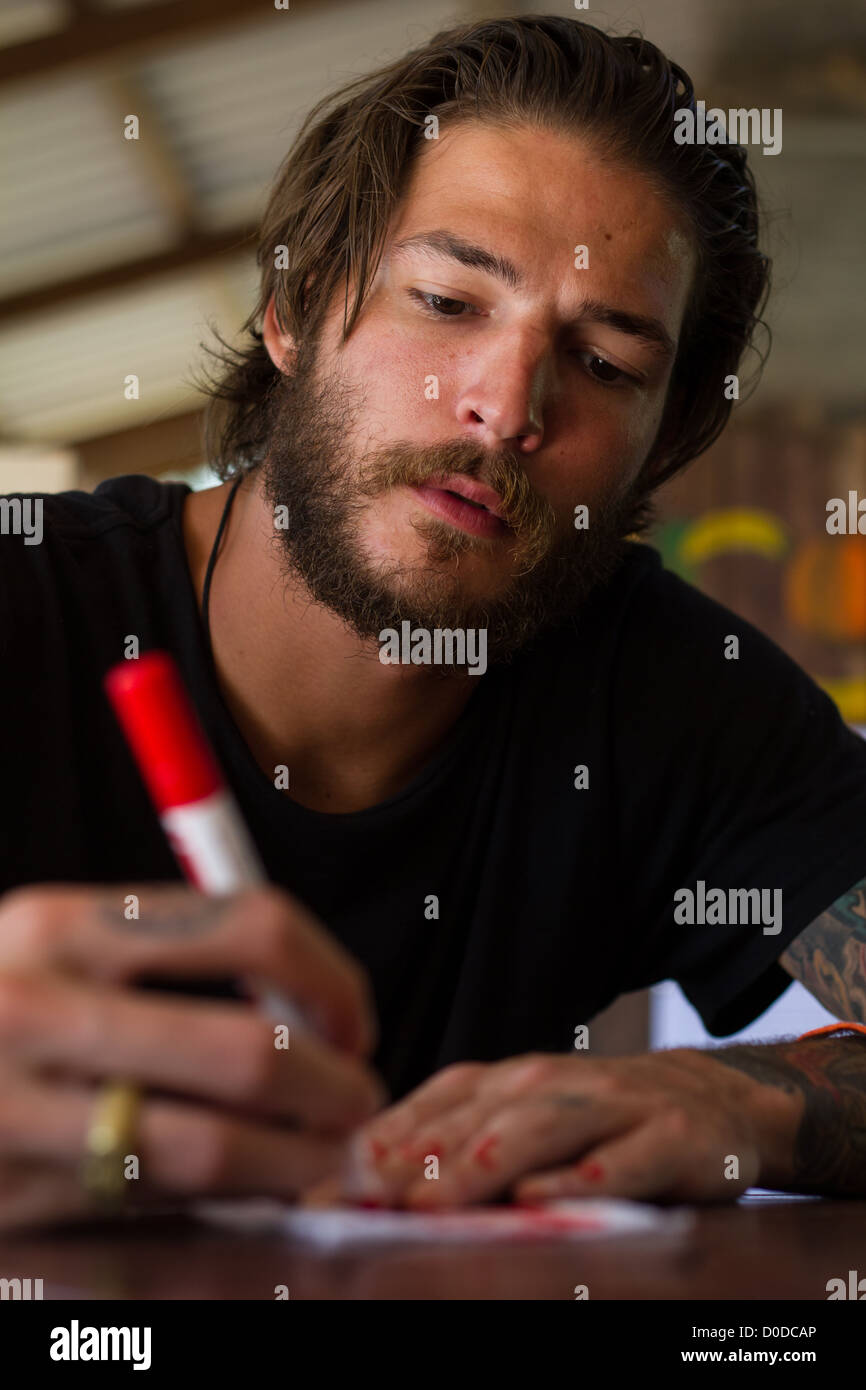 young man writing with red pen Stock Photo