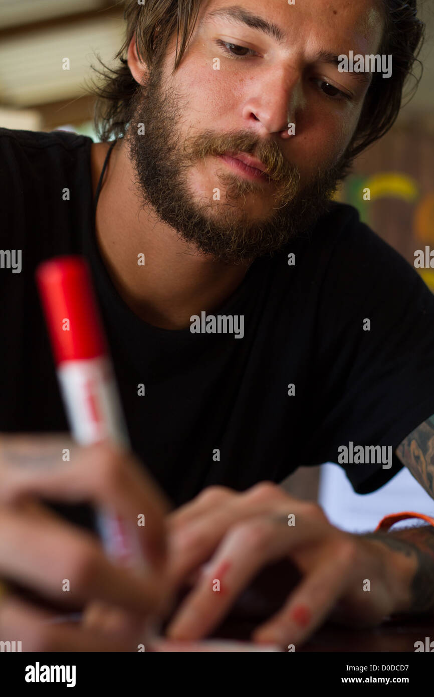 young man writing with red pen Stock Photo - Alamy