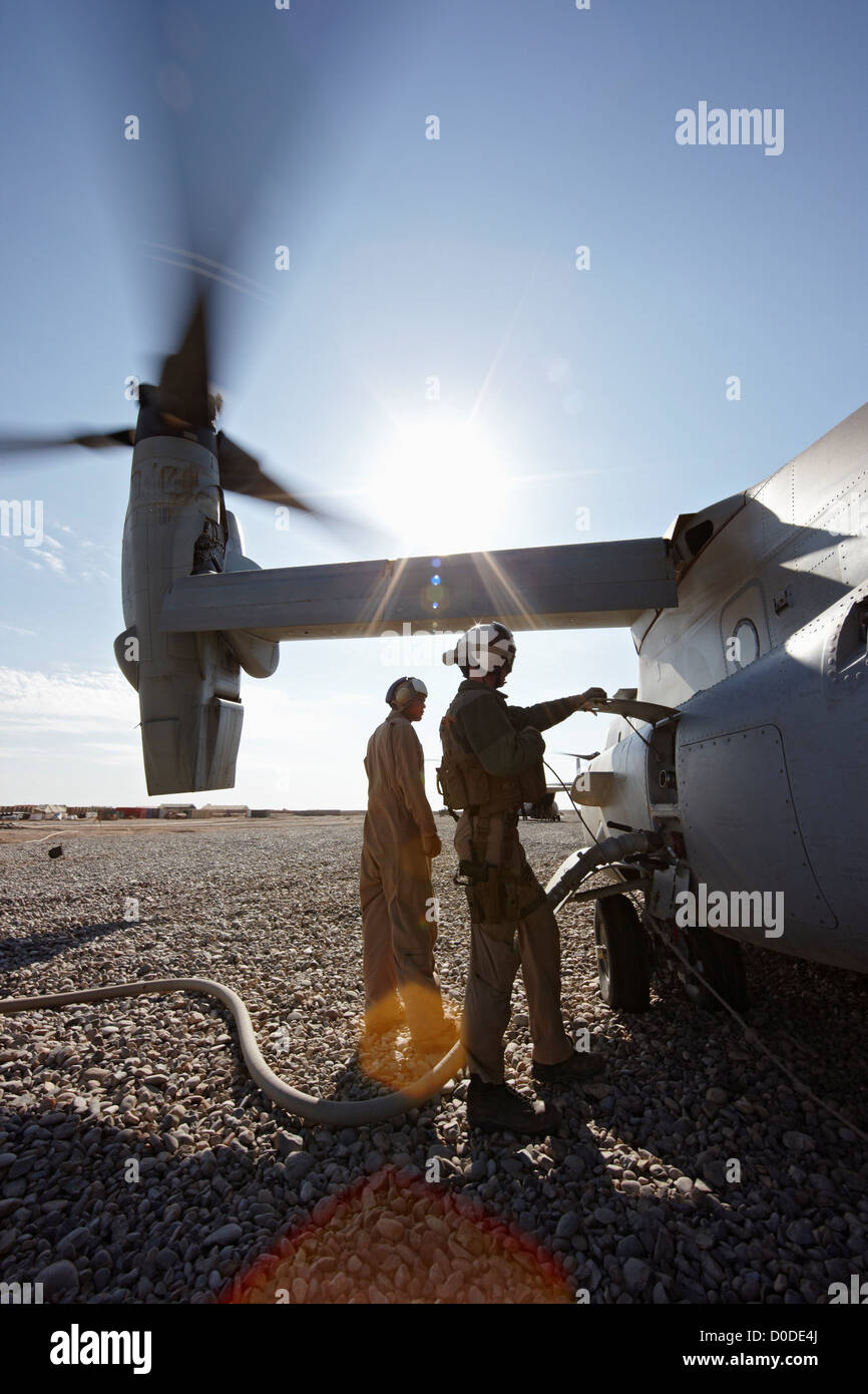 U.S. Marine ground crew refuel an idling MV-22 Osprey at a combat outpost in the Helmand Province of southern Afghanistan. Stock Photo
