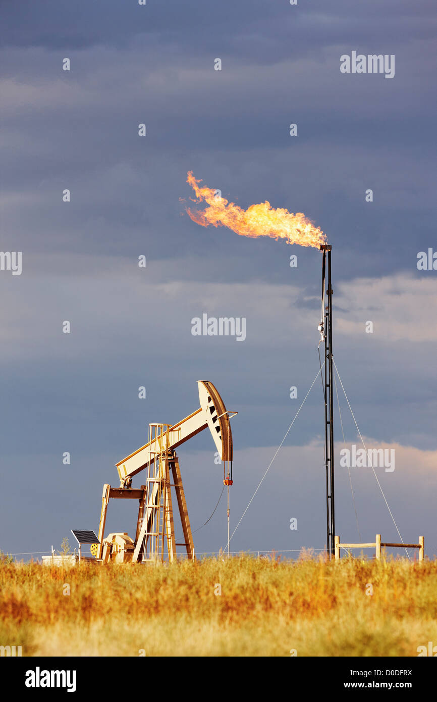 An oil well pump jack natural gas flare tower. pump jack is also known