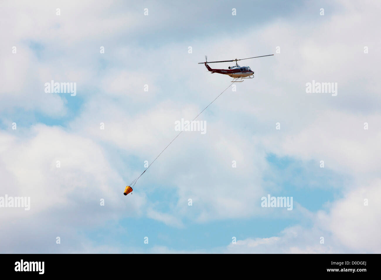 Firefighting helicopter carrying a bucket of water to a raging mountain