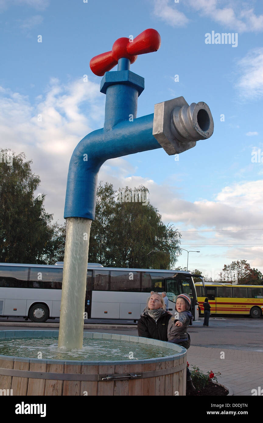 mother and her boy with statue tap flowing water against sky Stock Photo