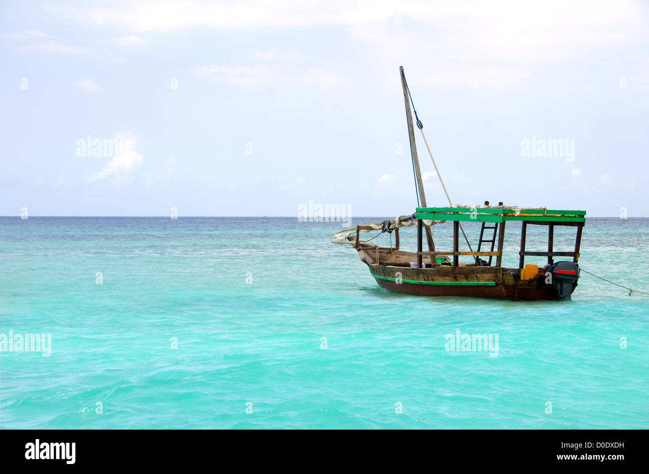 Wooden boat floating on the turquoise sea against blue sky Stock Photo ...