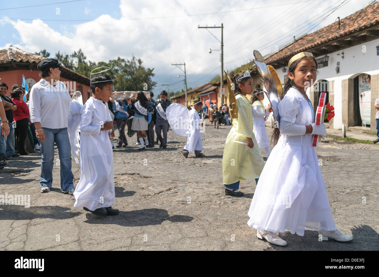 ANTIGUA GUATEMALA, Guatemala — During the morning on the day before Guatemalan Independence Day (which is celebrated on September 15), hundreds of school children from Antigua and the surrounding villages march in a parade of school groups in Antigua, some in costumes and others in their school uniforms. The parade includes school marching bands and cheerleaders as well. The procession starts at Parque Central and weaves its way past the bright yellow La Merced church and onto the municipal stadium. Stock Photo