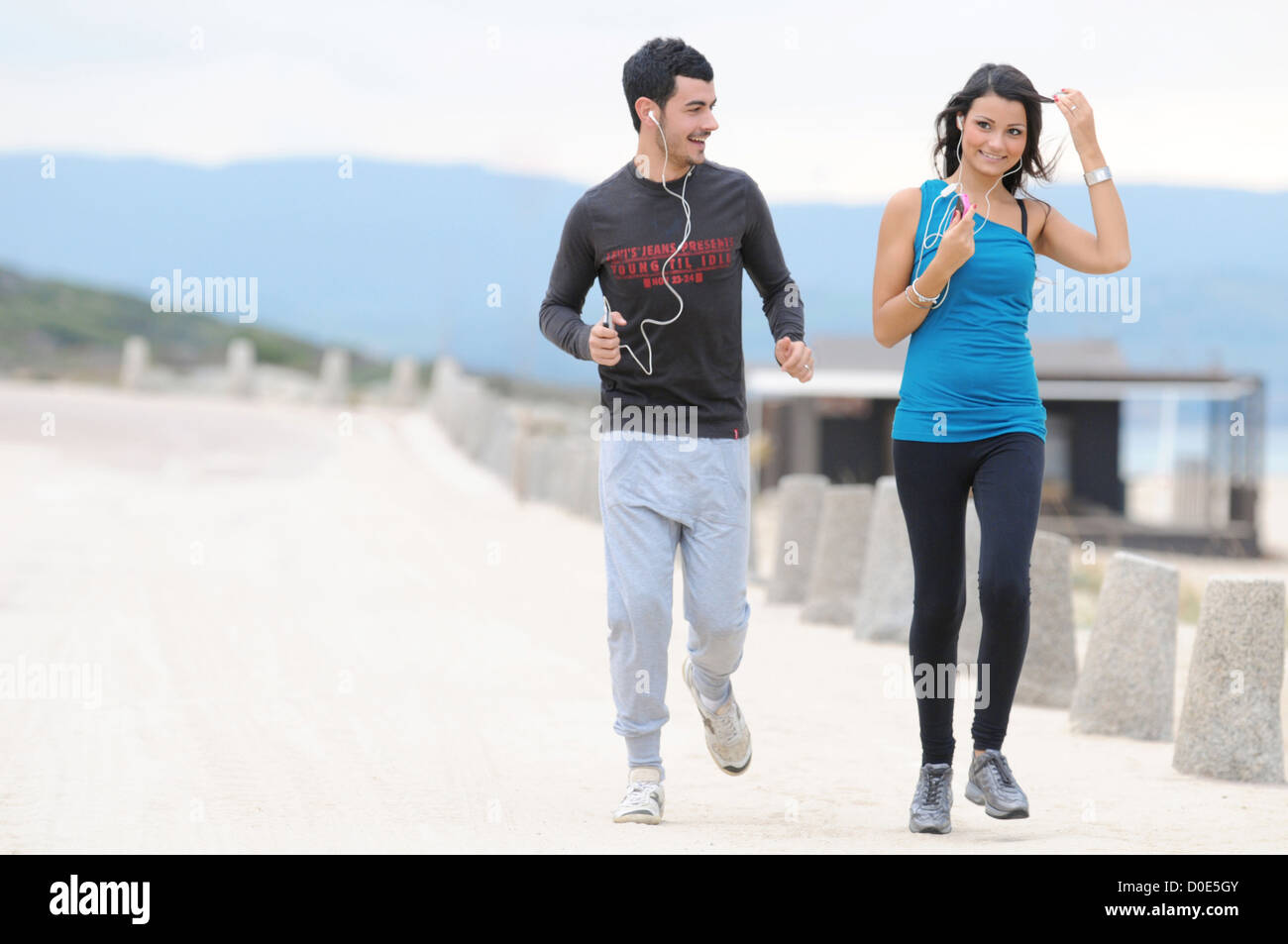 Young couple running and jogging on beach Stock Photo