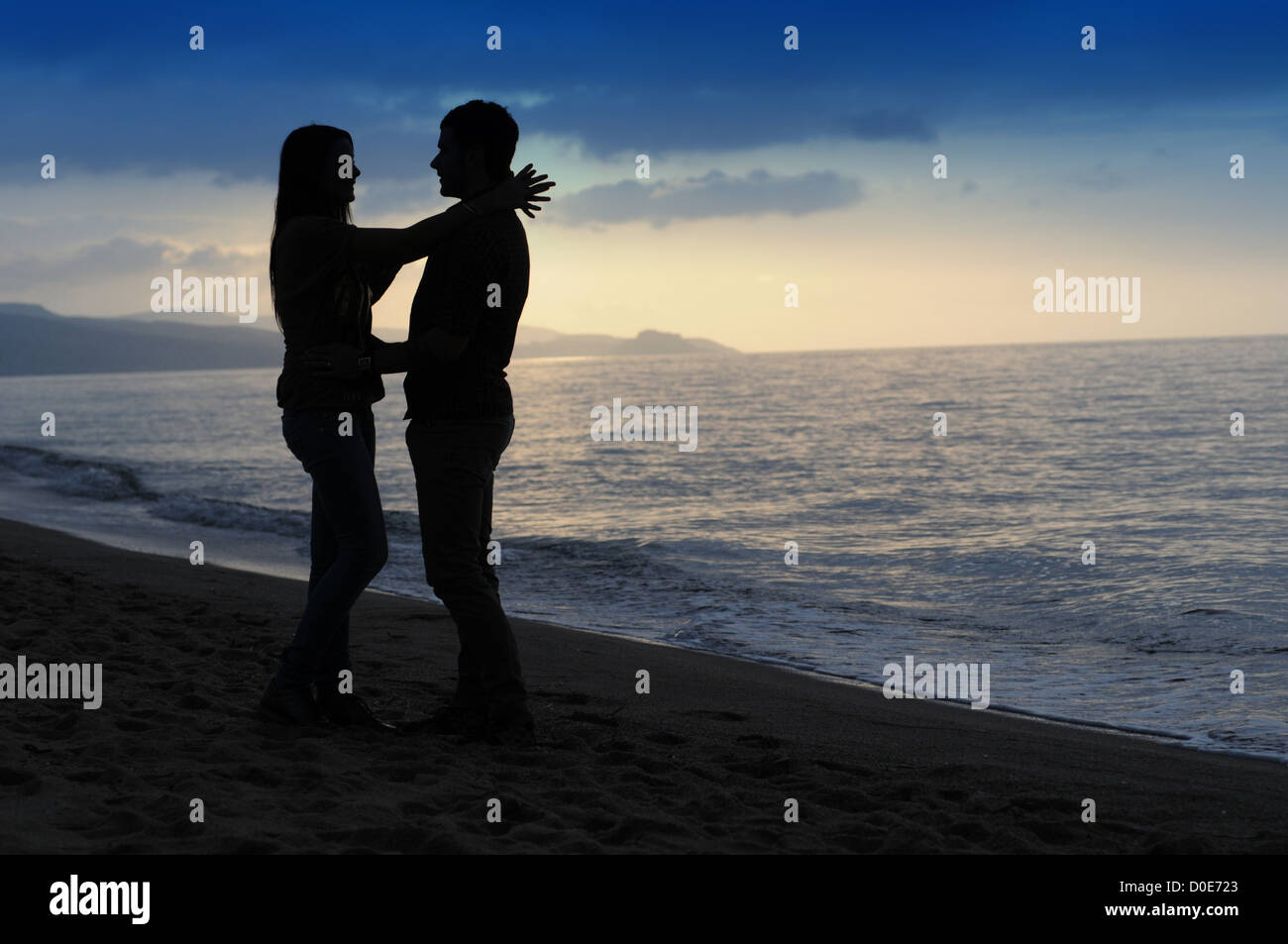 Young couple embracing at sunset Stock Photo