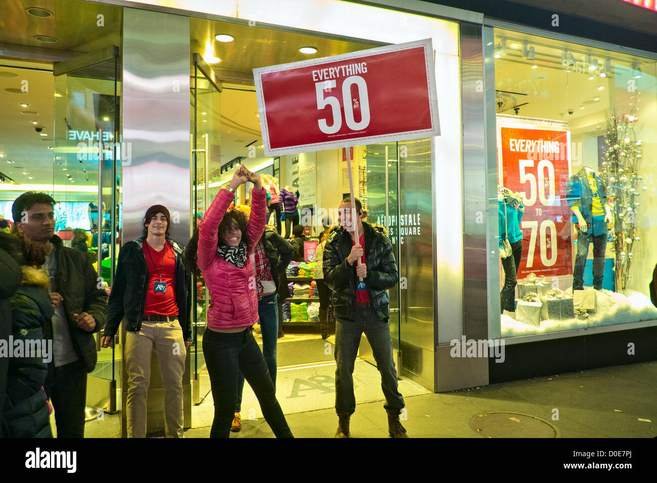 November 22, 2012, New York, NY.  A young woman dances in front of signs advertising 50% off at the Aeropostale store in New York's Times Square, which, like many stores, was open on the Thanksgiving Day holiday Stock Photo