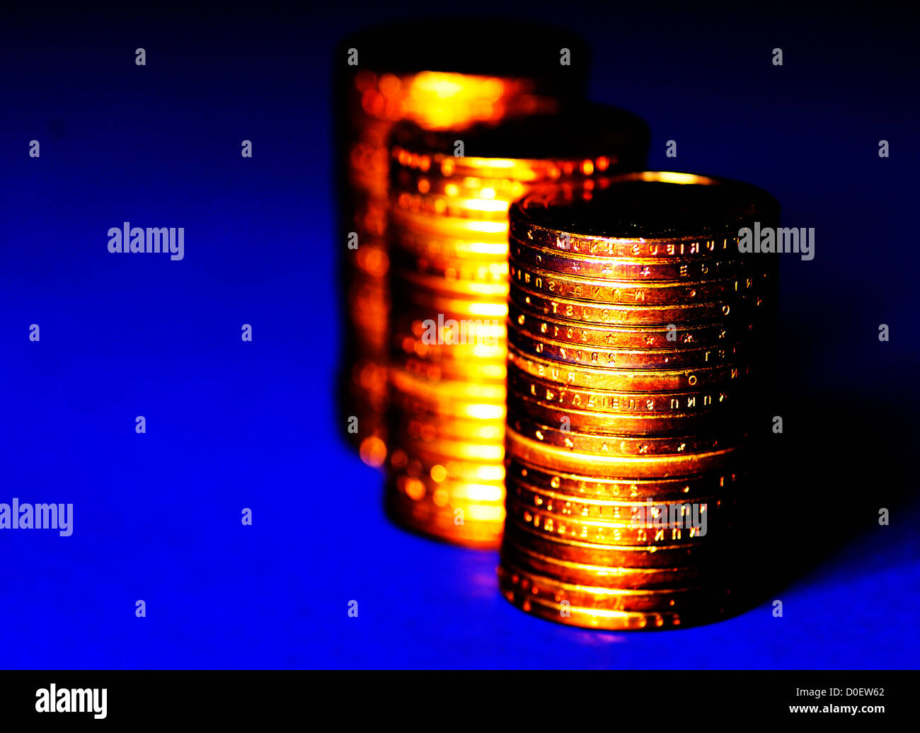 Several stacks of gold coins on blue background Stock Photo - Alamy