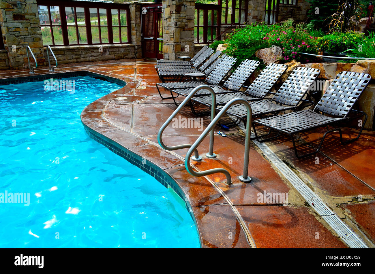 Deck chairs next to swimming pool with blue water Stock Photo Alamy
