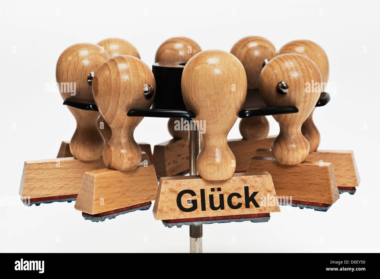 Many stamps hanging in a stamp rack, one with the German inscription Glück (Luck), background white. Stock Photo