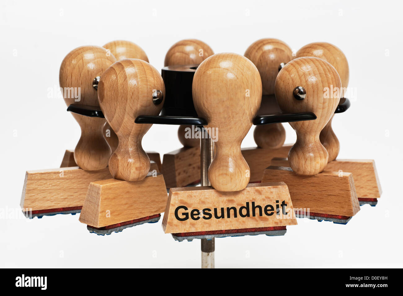 Many stamps hanging in a stamp rack, one with the German inscription Gesundheit (Health), background white. Stock Photo