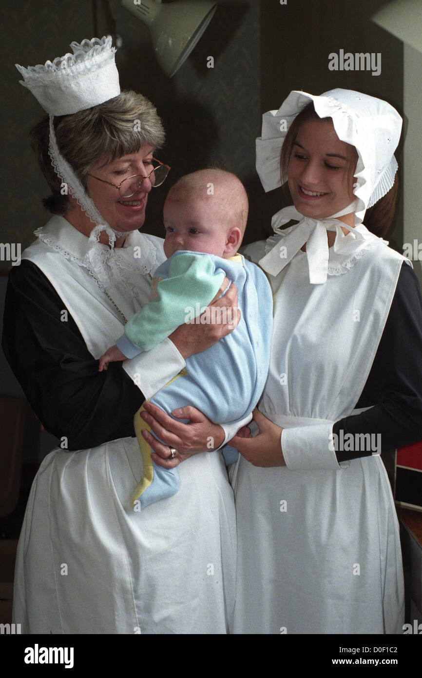 Nurses dressed in Victorian uniforms holding a baby at The Royal Hospital in Wolverhampton in 1997. Britain British NHS National Health Service uniform historic Stock Photo