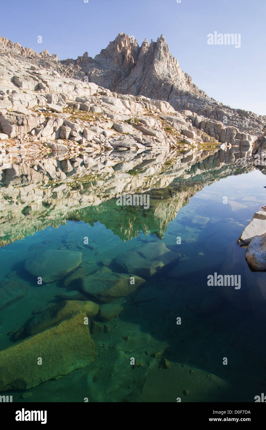 blue mountain lake with reflection of granite rocks and peaks Stock Photo