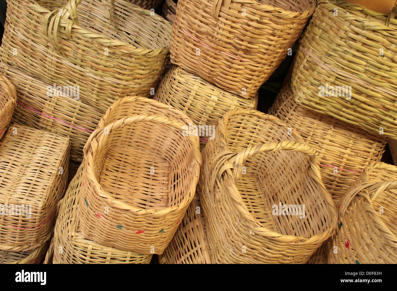 An abstract pile of handmade woven beige colored baskets for sale at the outdoor craft market in Otavalo, Ecuador Stock Photo