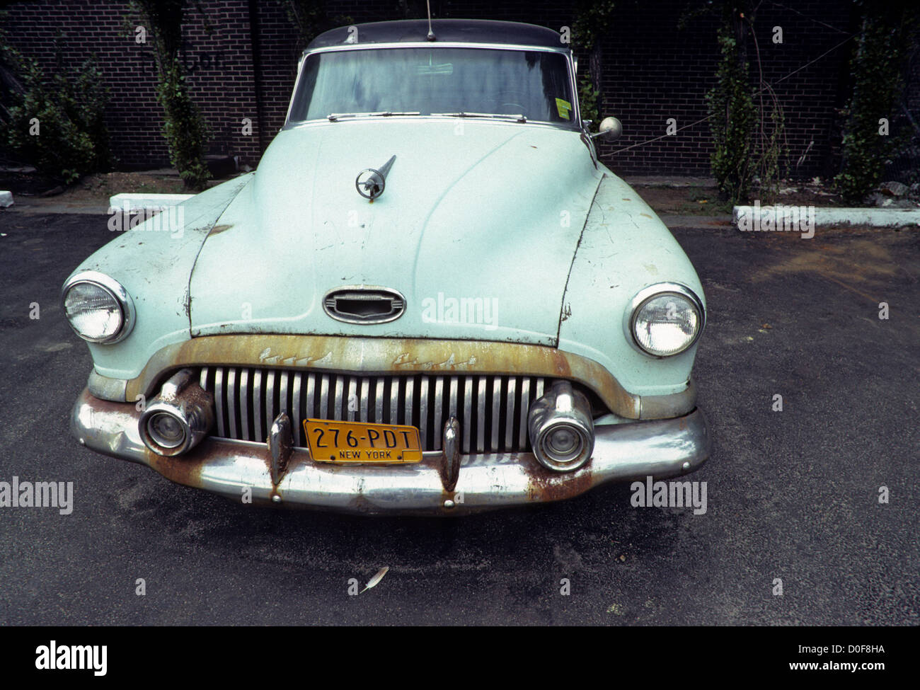 New York, NY -  May 1980 - Houston Street, rusty old circa 1950 Seafoam Green Buick Roadmaster automobile and a feather. Stock Photo