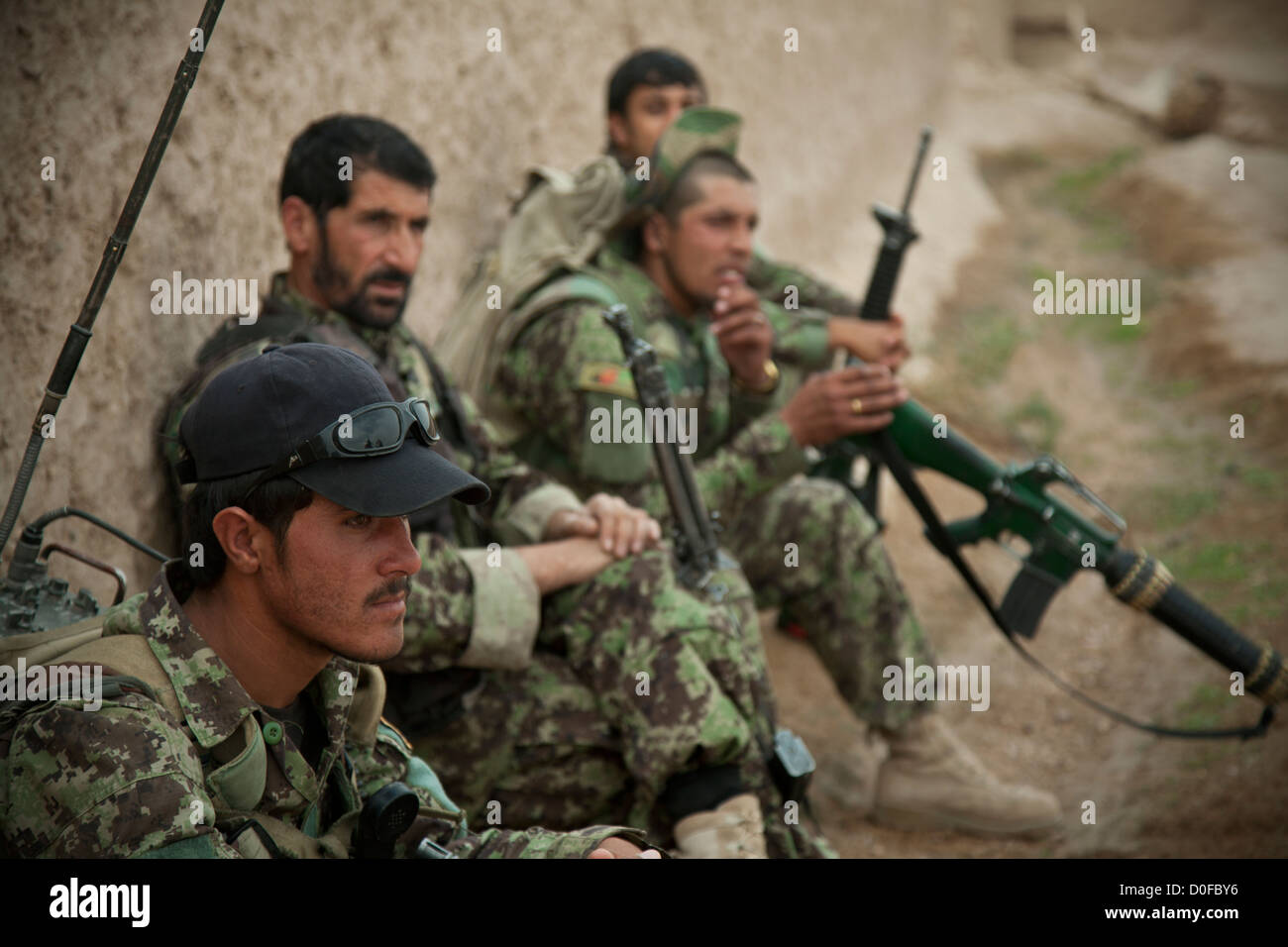 Afghan National Security Forces rest during a joint security patrol with US Special Force members October 30, 2012 in Khak-E-Safed, Farah province, Afghanistan. Afghan forces have been taking the lead in security operations with coalition forces as mentors. Stock Photo