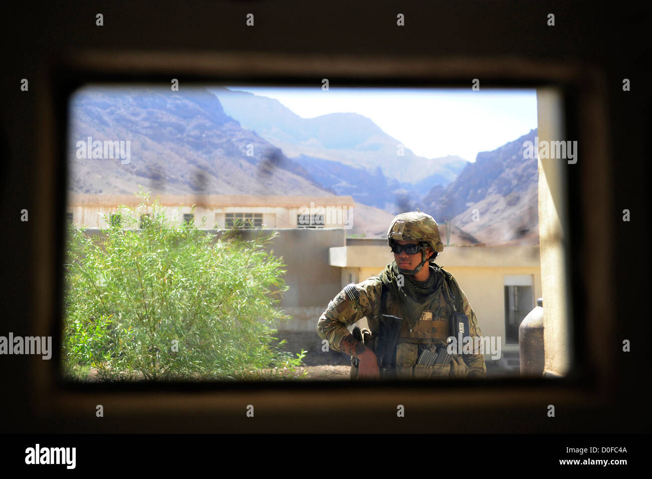 US Navy corpsman guarding a compound seen through the window of an armored vehicle September 26, 2012 during a mission to Pur Chaman district, Farah province, Afghanistan. The mission marks the first time coalition forces have been to the Pur Chaman district in over a year. Stock Photo