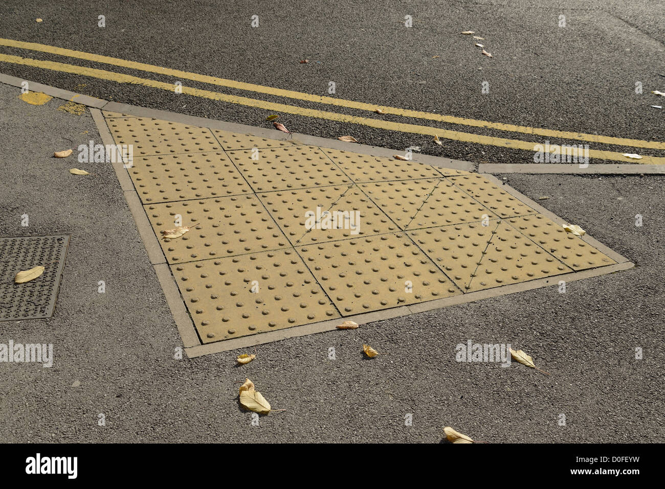 Tactile paving at the crossing point of a road to help visually impaired people avoid danger. Stock Photo