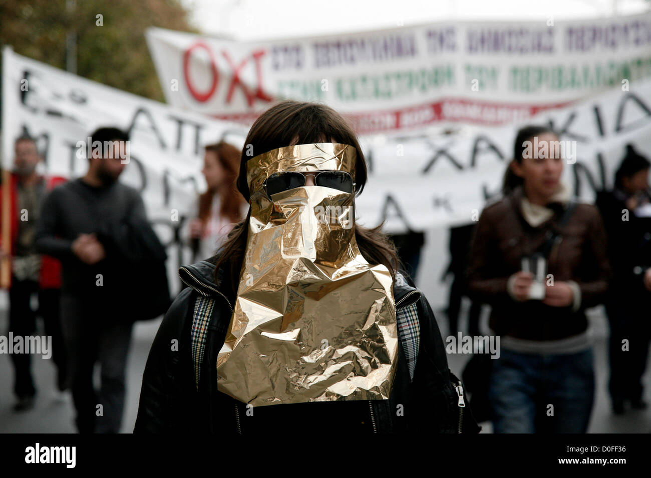 Thessaloniki,Greece. November 24, 2012. Demonstrator wearing a improvised mask of gold wrapping paper. Thousands of people flooded the streets of Thessaloniki to protest against efforts by Hellas Gold, a subsidiary of the Canadian firm Eldorado Gold, to mine the Skouries quarry on Mount Kakkavos, in the Halkidiki peninsula and the city of Kilkis in northern Greece. Stock Photo