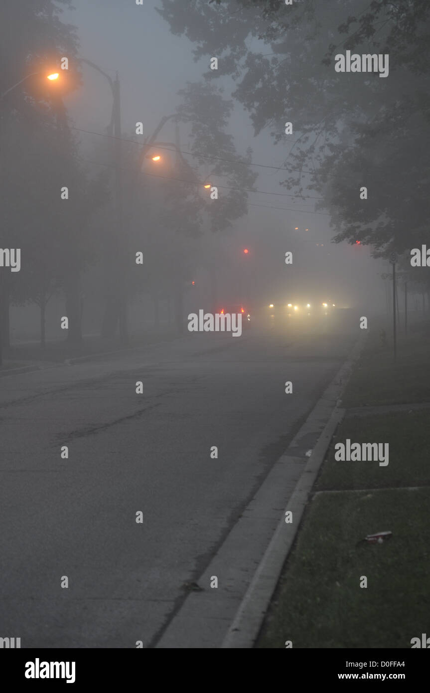 A row of city street lights engulfed in fog in early morning, London