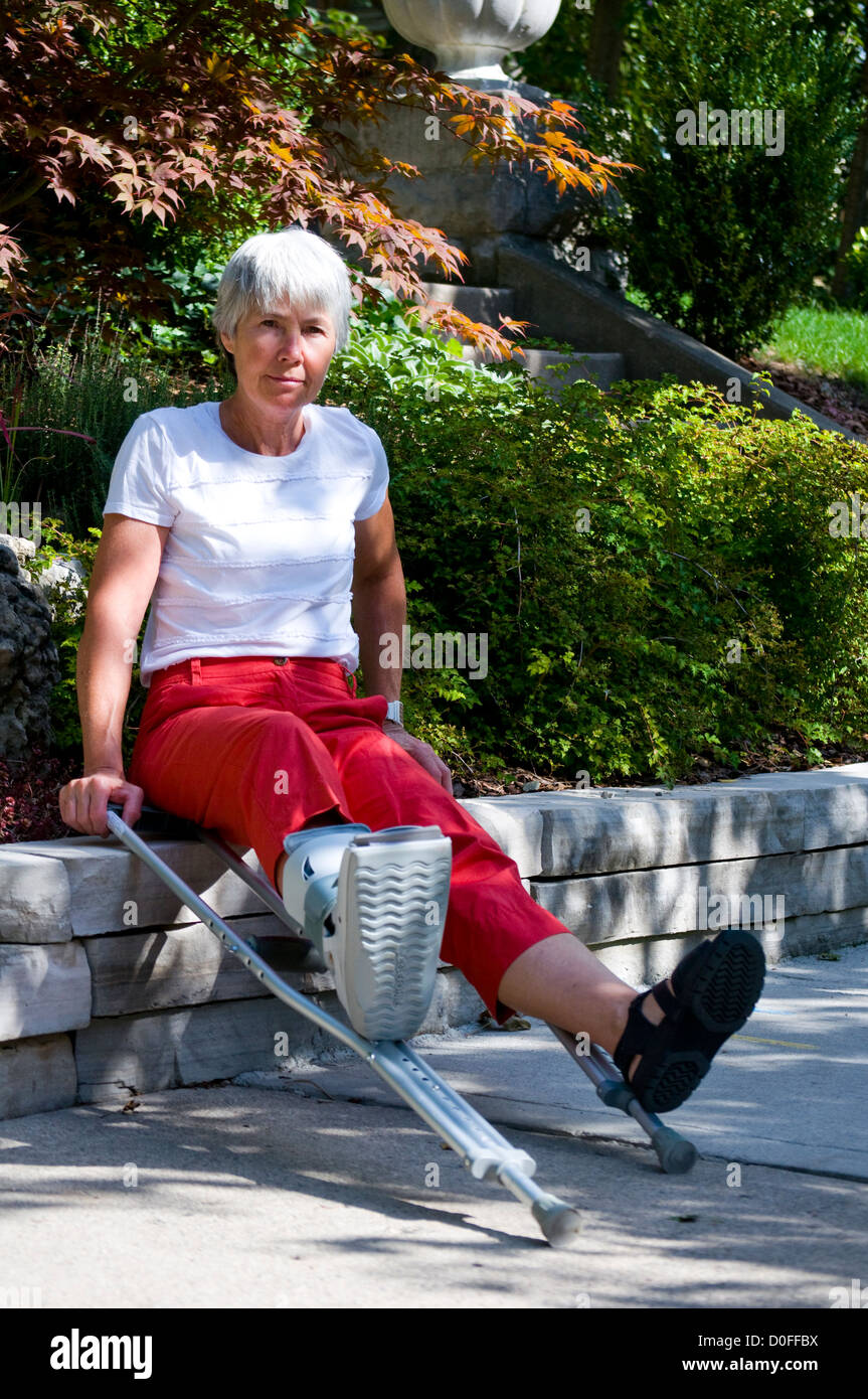 A woman with a hurt foot rests on her crutches on a ledge, Ontario, Canada Stock Photo Alamy