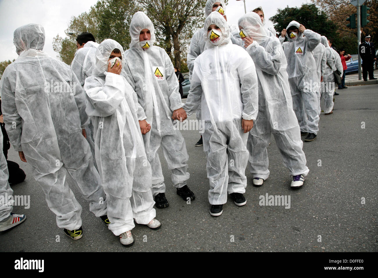Thessaloniki,Greece. November 24, 2012. Young demonstrators wearing chemical protection suits. Thousands of people flooded the streets of Thessaloniki to protest against efforts by Hellas Gold, a subsidiary of the Canadian firm Eldorado Gold, to mine the Skouries quarry on Mount Kakkavos, in the Halkidiki peninsula and the city of Kilkis in northern Greece. Stock Photo