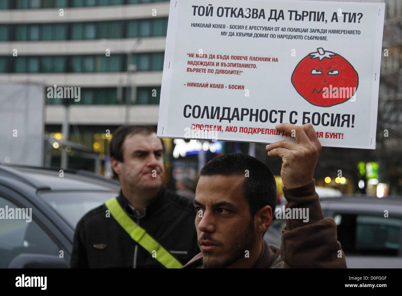 Sofia, Bulgaria; 24th November, 2012. Demonstrator holding aup a sign with the tomato, symbol of the new Bulgarian anti-establishment movement 'Tomato Revolution'. The sign also describes the arrest of dissident Nikolay Kolev by 40 police officers four days earlier. Credit:  Johann Brandstatter / Alamy Live News Stock Photo