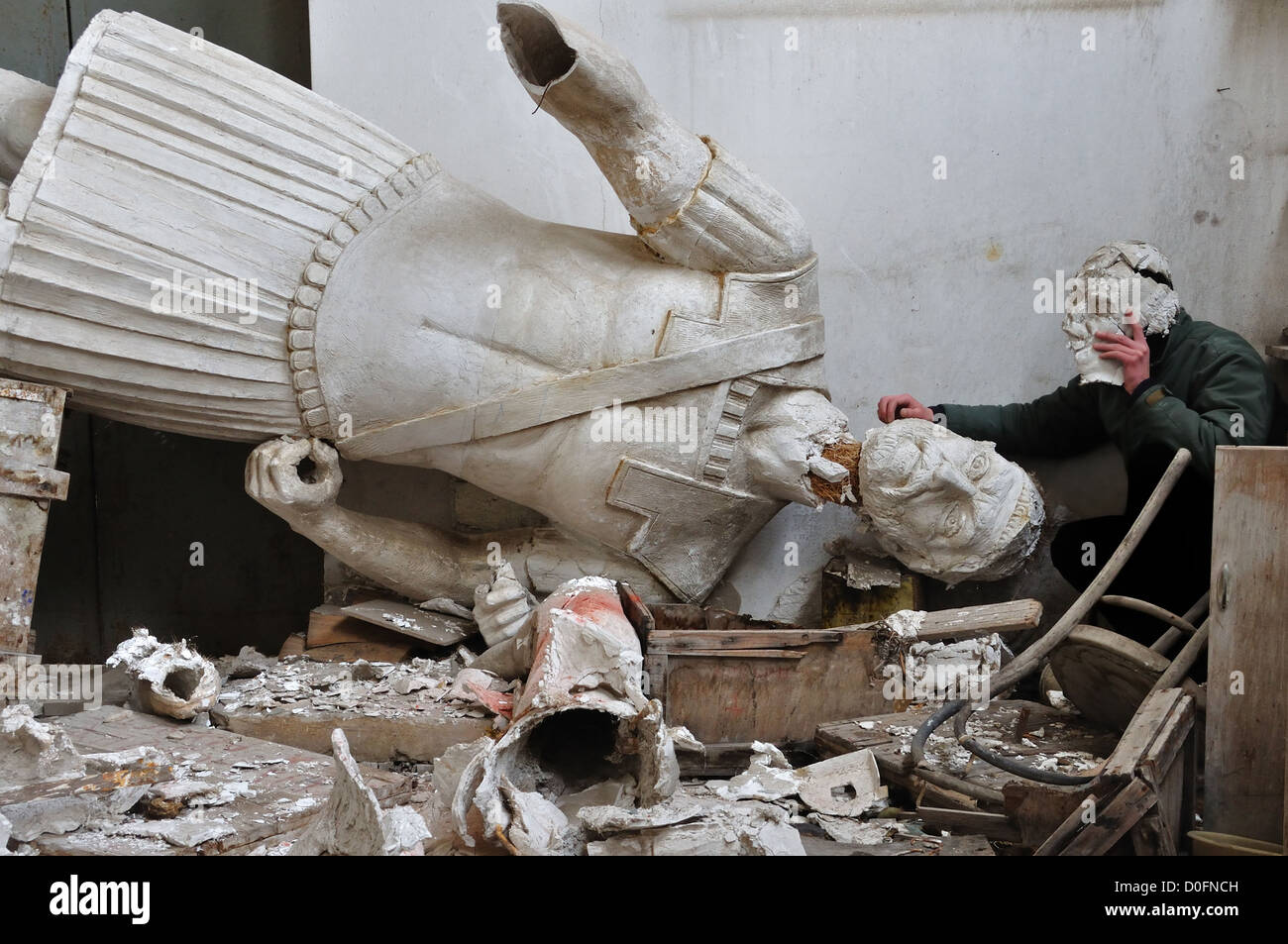 Broken statue of ancient god in the vandalized studio of sculptor