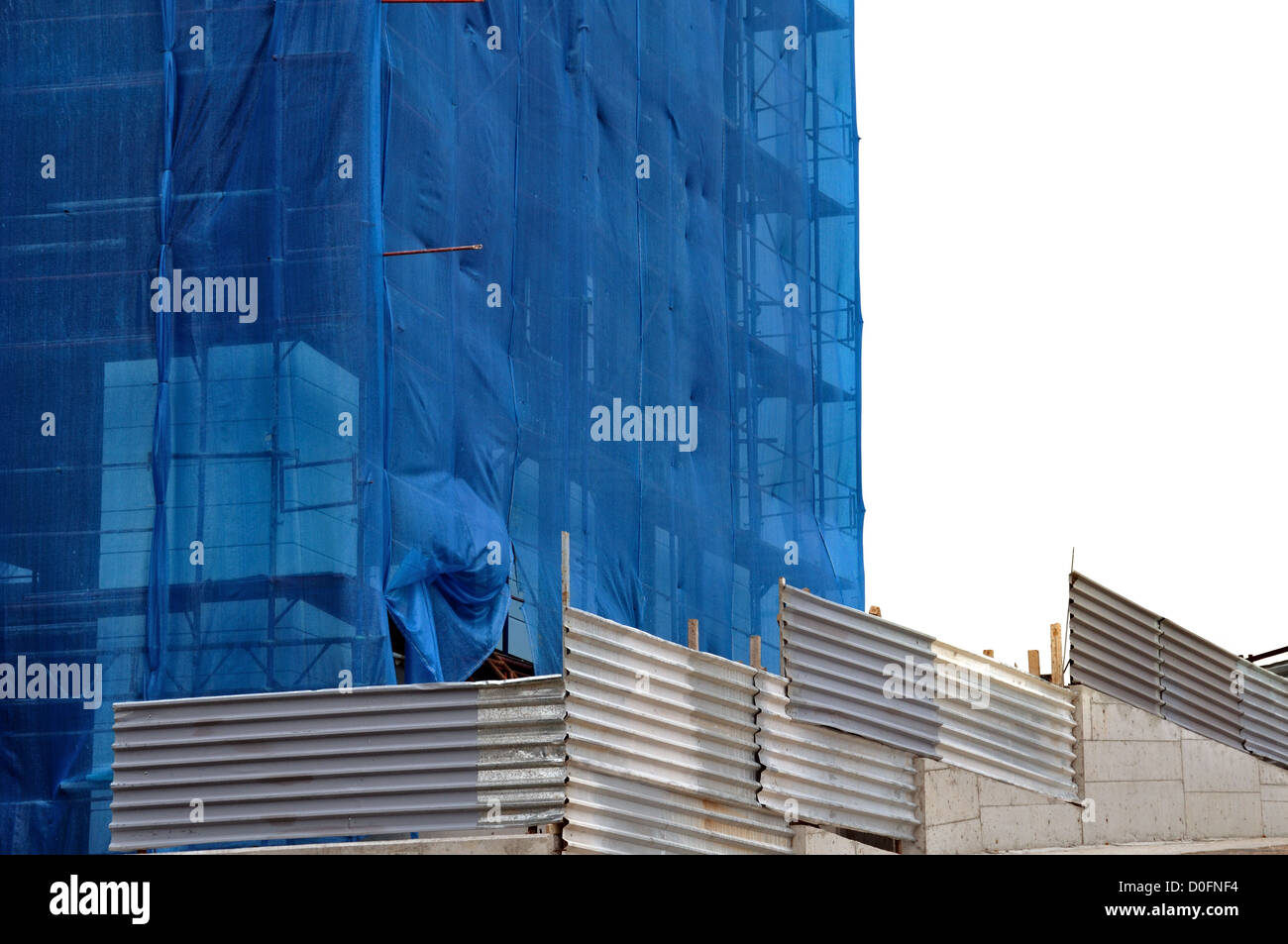 Building covered with construction debris netting. Aluminum fence and scaffold. Stock Photo