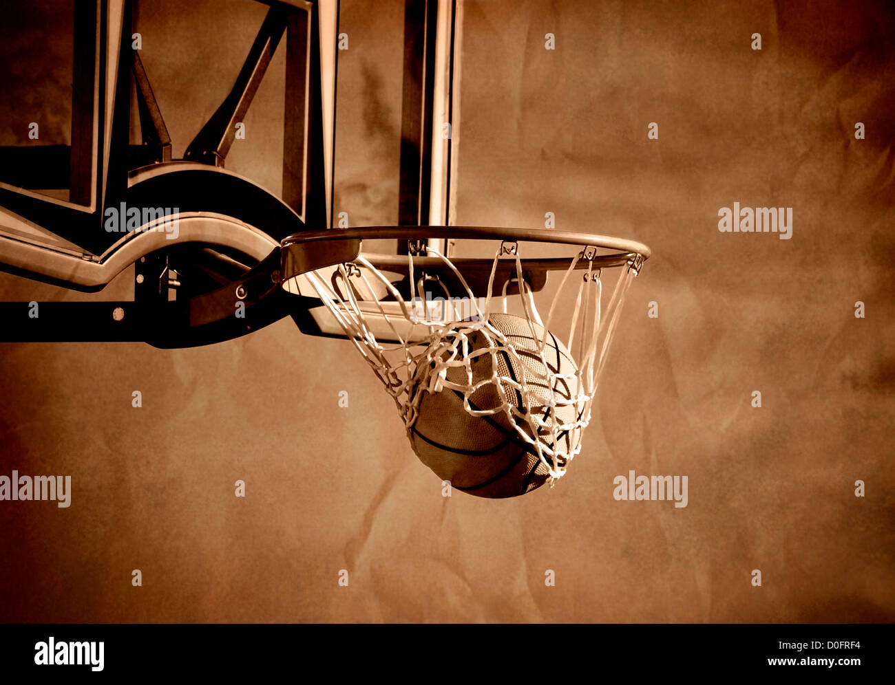 Action shot of basketball going through basketball hoop and net Stock Photo