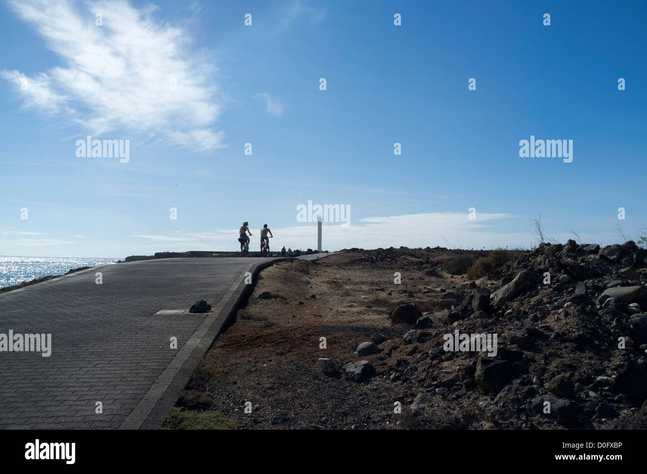 dh Faro de Pechiguera lighthouse PLAYA BLANCA LANZAROTE Tourist couple cyclists lighthouses cycling holiday young people couples riding cycles Stock Photo