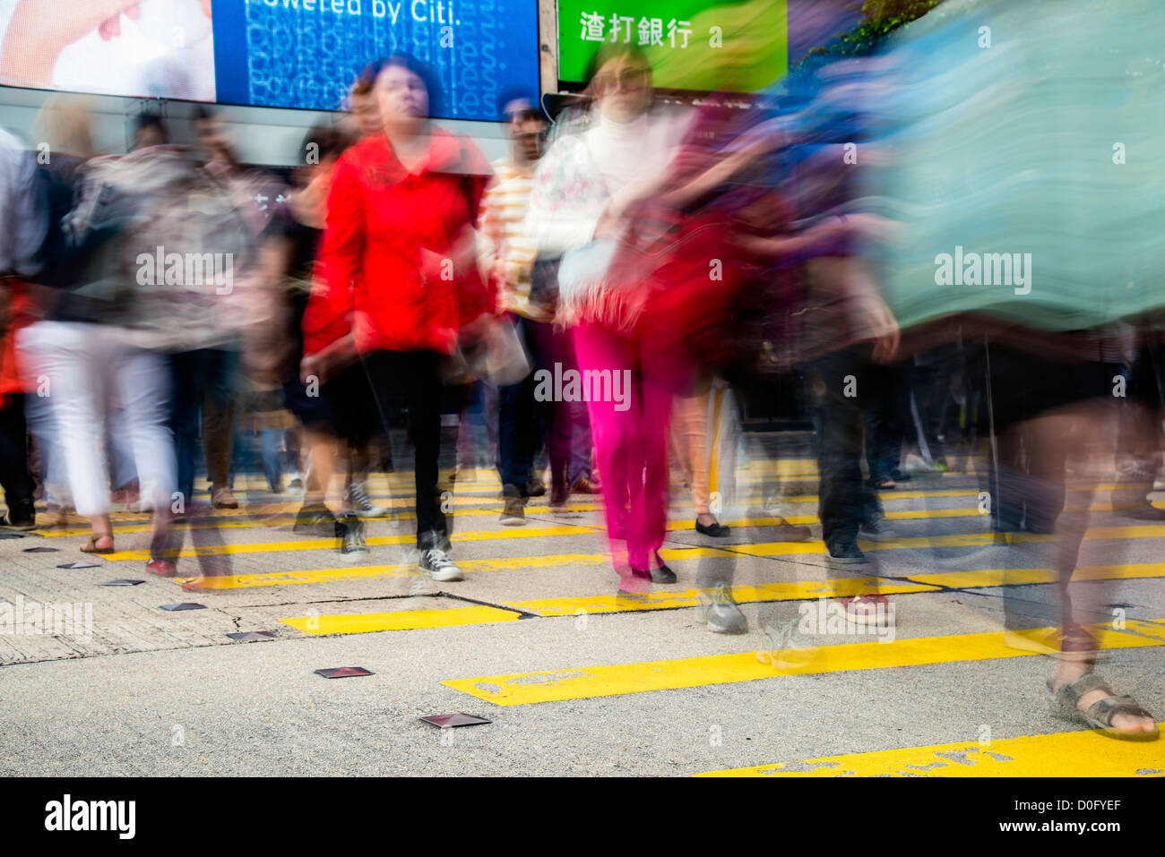 Pedestrians in blurred motion while crossing Nathan Road, Kowloon, Hong Kong, China Stock Photo