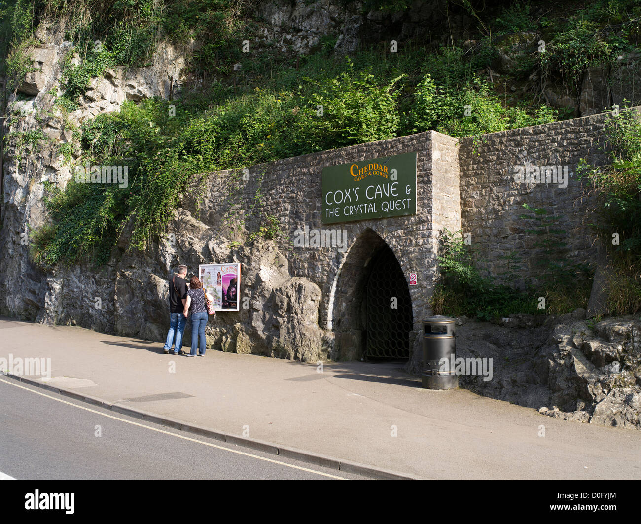 dh Cheddar Gorge cave CHEDDAR SOMERSET Tourist couple entrance to Cheddar Gorge caves mendips people uk mendip hills Stock Photo