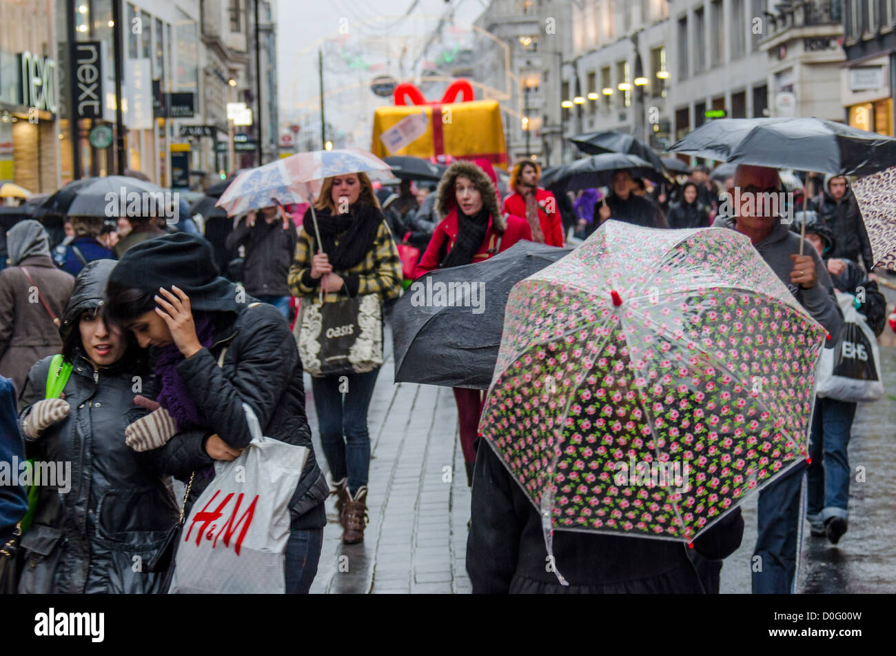Christmas Shoppers in the rain on Oxford Street, London during the West End Shopping weekend with the road closed to traffic. Stock Photo