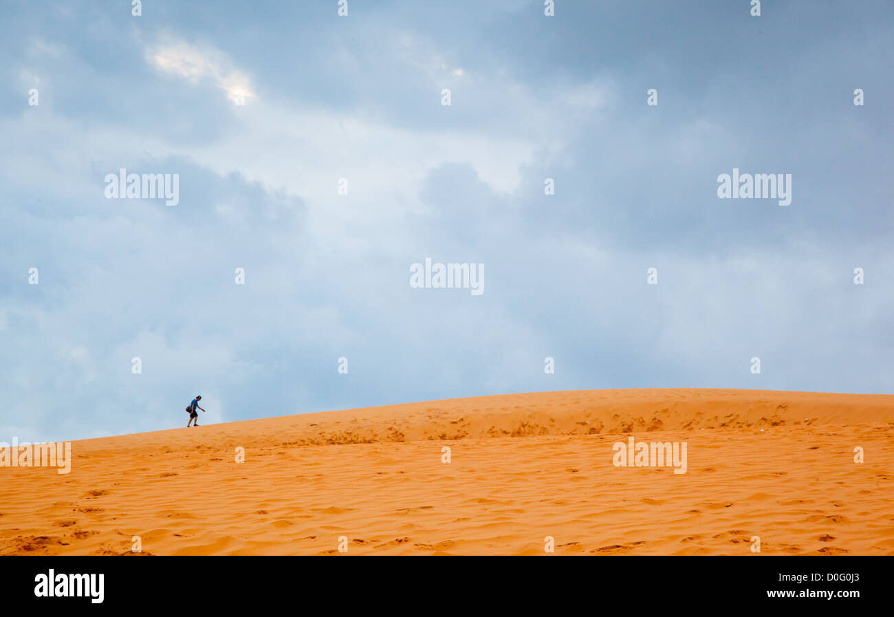 Man walking on sand dunes Stock Photo