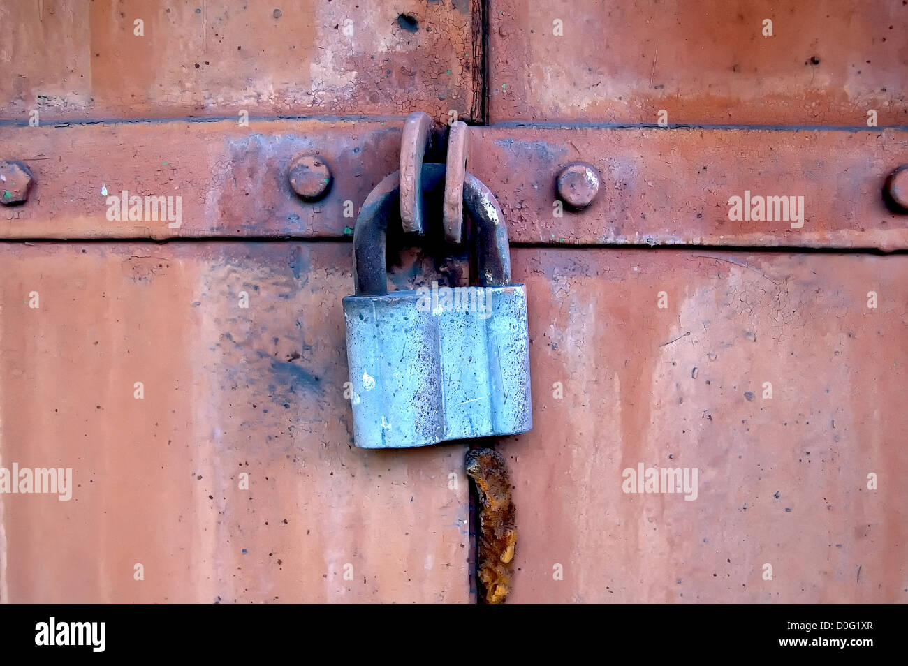 The old steel door closed on the hanging metal lock Stock Photo - Alamy